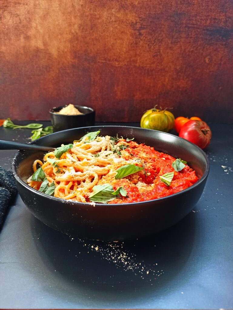 Vegane Nudeln in Tomatensauce mit Hafer-Mandel Parmesan.